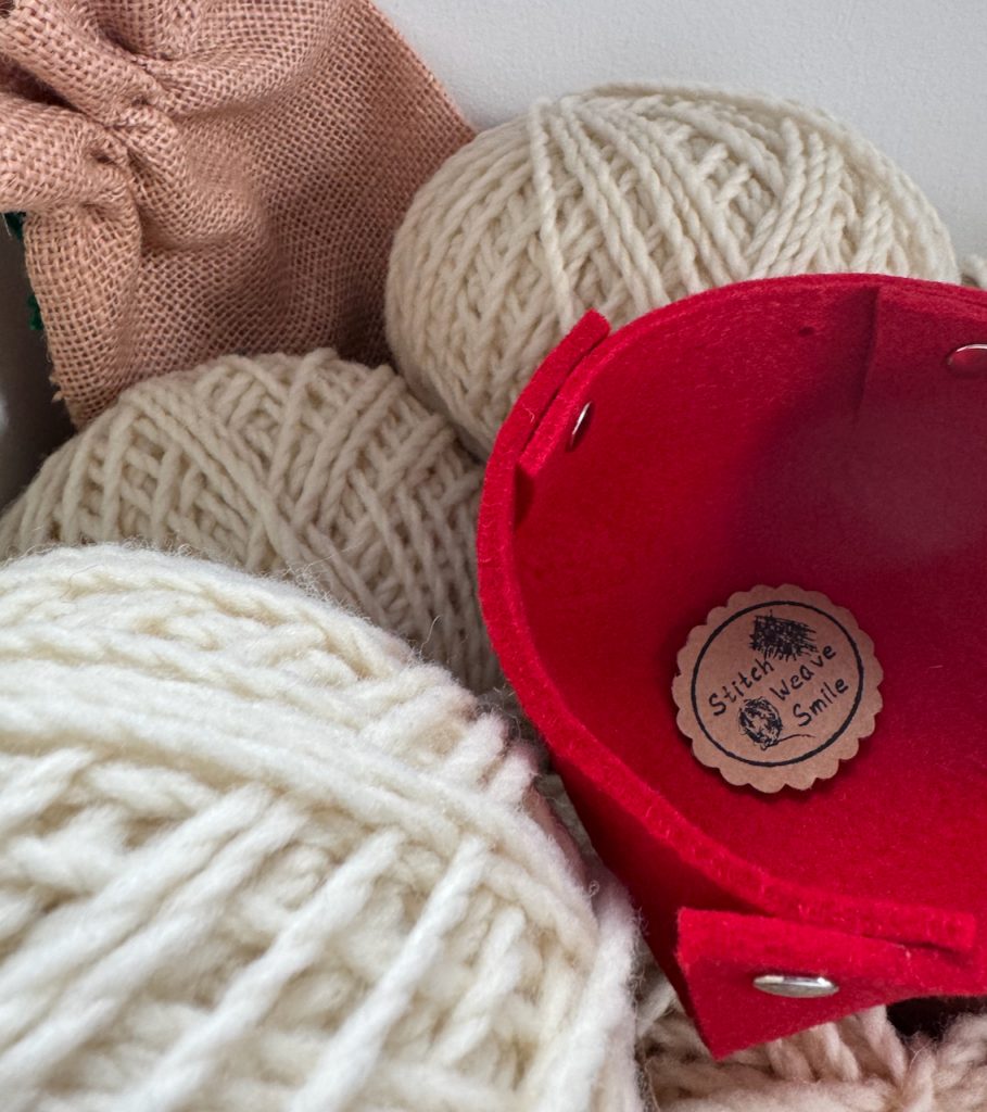 Wollknäuel weiß mit rotem Filzkorb