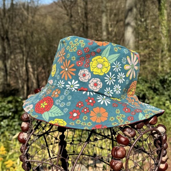Wende-Sonnenhut aus beschichteter Baumwolle mit Blumenmuster, mit Zopfloch