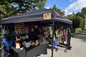 Stand StitchWeaveSmile Kreativmarkt Cafe Mandel 2 @StitchWeaveSmile Pavillon vor blauem Himmel und Baum, Verkaufsstand mit handgemachten Sachen