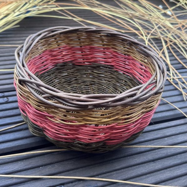 Korb aus farbigem Peddigrohr in Braun- und Rottönen