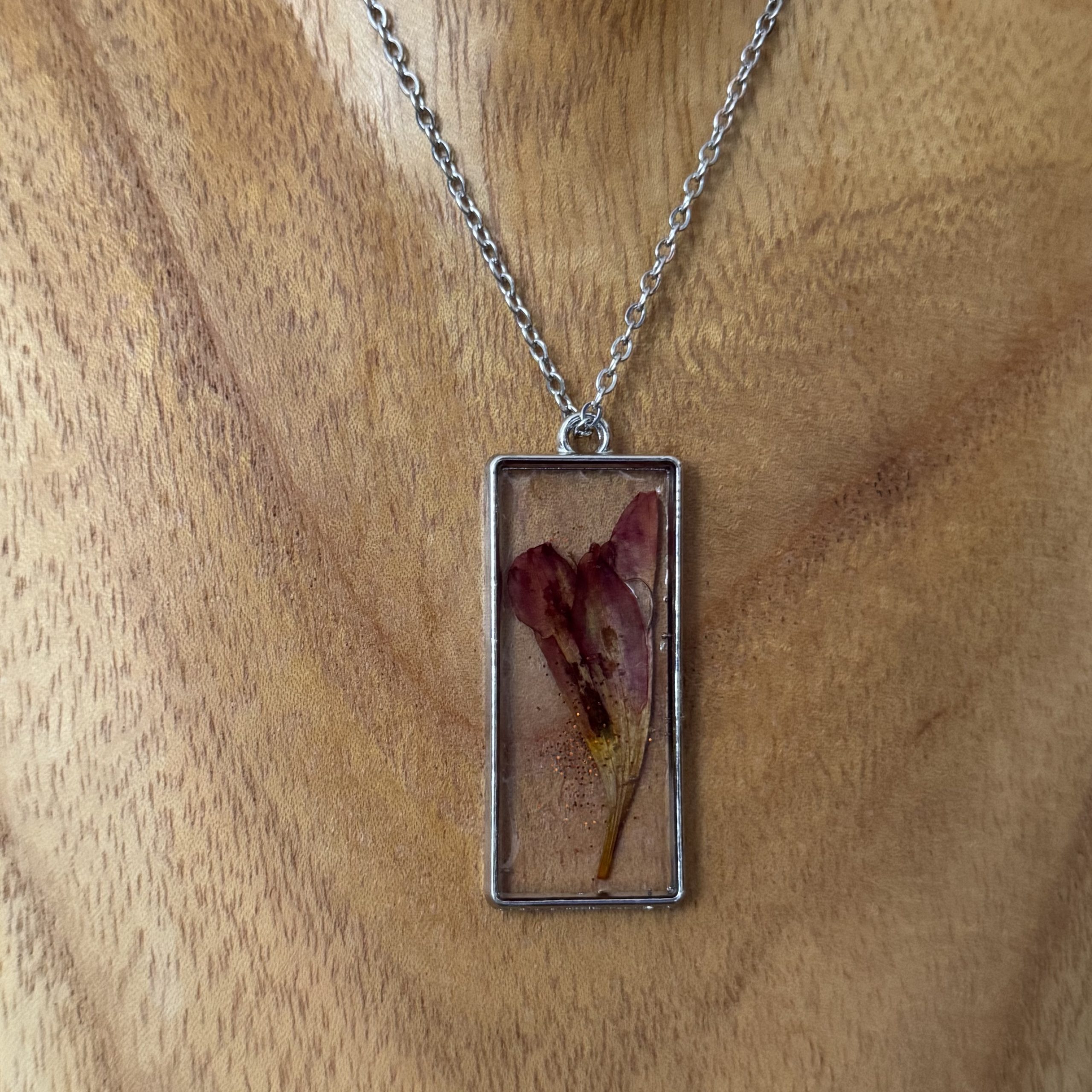 Kette mit in UV Resin eingegossener Trockenblume in silberfarbenem, rechteckigem Rahmen