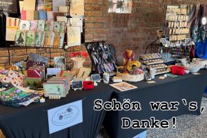 Verkaufsstand Hagen 2025_11-1 ©StitchWeaveSmile Verkaufsstand vor Backsteinwand mit Büchern, Taschen, Schmuck, Körben