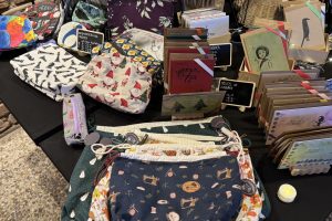 Verkaufsstand Hagen 2025_11-3 ©StitchWeaveSmile Verkaufsstand vor Backsteinwand mit Büchern, Taschen, Schmuck, Körben