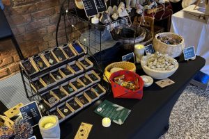 Verkaufsstand Hagen 2025_11-3 ©StitchWeaveSmile Verkaufsstand vor Backsteinwand mit Büchern, Taschen, Schmuck, Körben